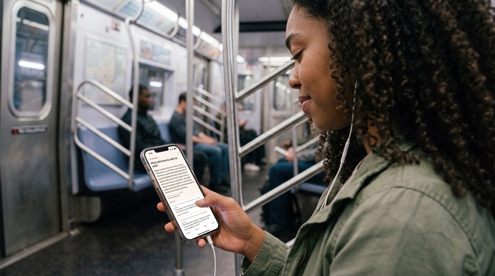 Close-up of the app's Ask screen while a woman listens on the subway